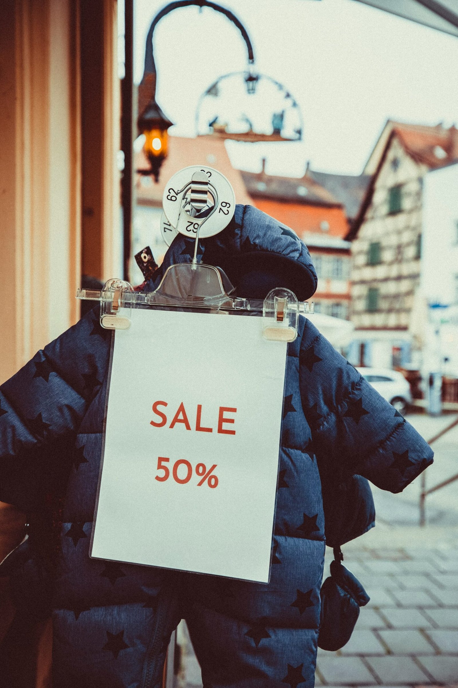 a sale sign attached to a jacket on a street